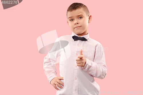 Image of The teen boy point you. portrait on pink background.