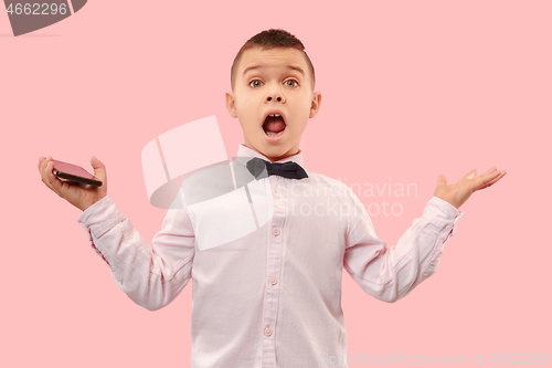 Image of The young attractive teen boy looking suprised isolated on pink