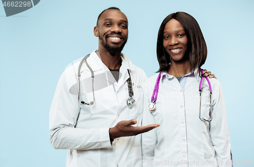 Image of The female and male happy afro american doctors on blue background