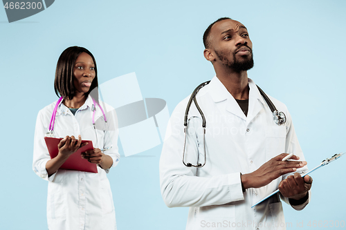 Image of The female and male happy afro american doctors on blue background