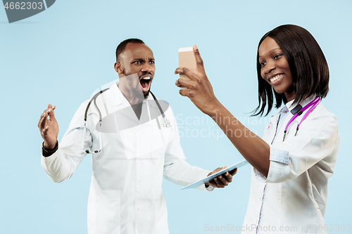 Image of The female and male happy afro american doctors on blue background