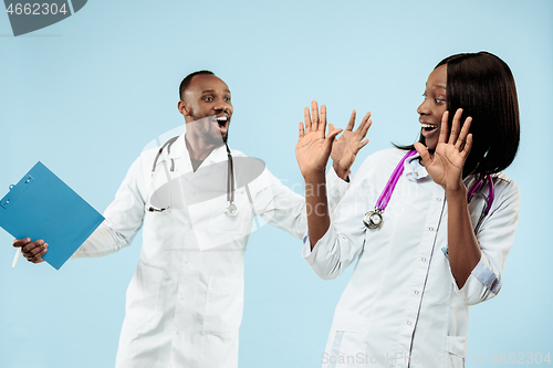 Image of The female and male happy afro american doctors on blue background