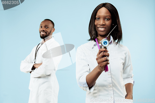 Image of The female and male happy afro american doctors on blue background