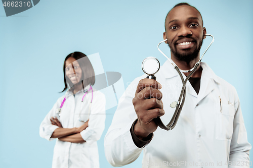 Image of The female and male happy afro american doctors on blue background