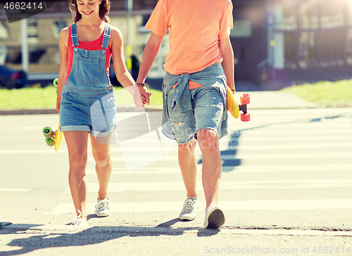 Image of teenage couple with skateboards at city crosswalk