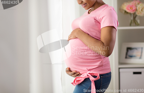 Image of happy pregnant woman with big belly at home