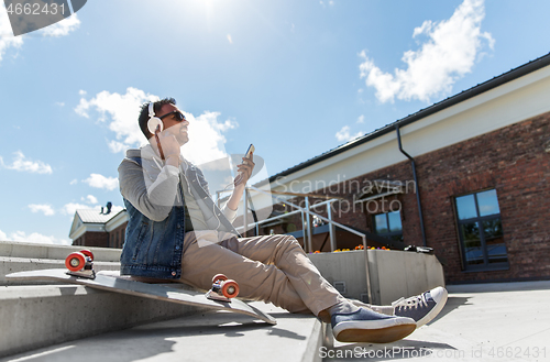 Image of man with smartphone and headphones on roof top