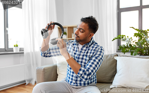 Image of male blogger with headphones videoblogging at home