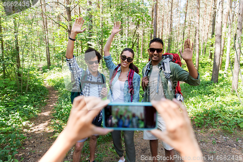 Image of friends with backpacks being photographed on hike