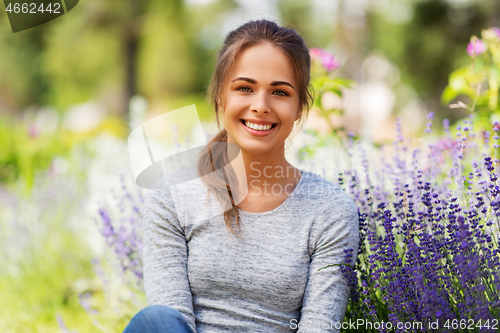 Image of young woman with flowers at summer garden