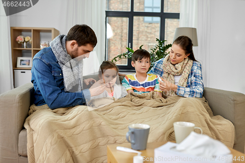 Image of family with medicine treating ill children at home