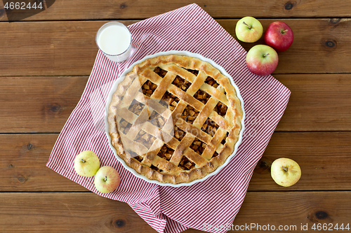 Image of apple pie in baking mold on wooden table