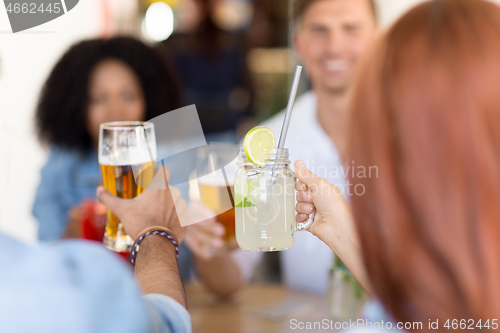 Image of friends clinking glasses at bar or restaurant