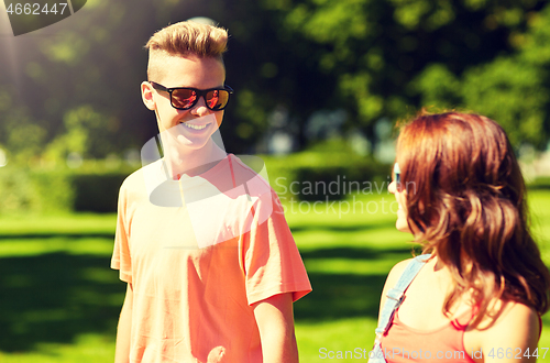 Image of happy teenage couple walking at summer park