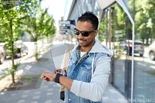 Image of indian man with smart watch and backpack in city