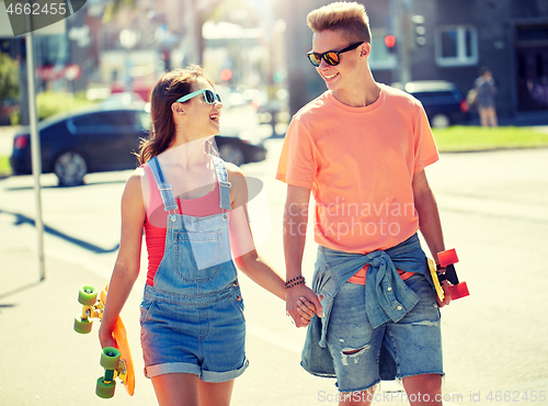 Image of teenage couple with skateboards on city street