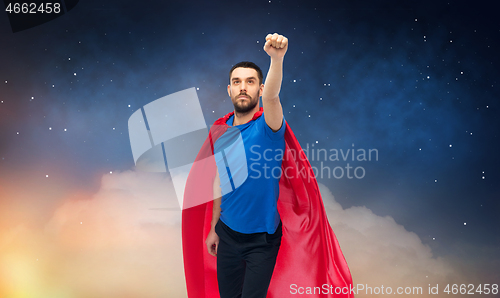 Image of man in red superhero cape over night sky