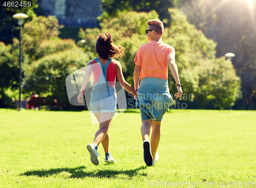 Image of happy teenage couple walking at summer park