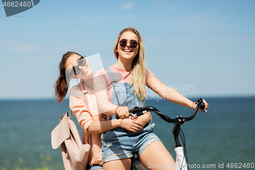 Image of teenage girls or friends riding bicycle in summer