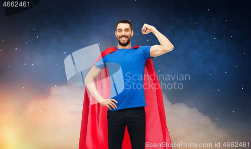 Image of happy man in red superhero cape over night sky