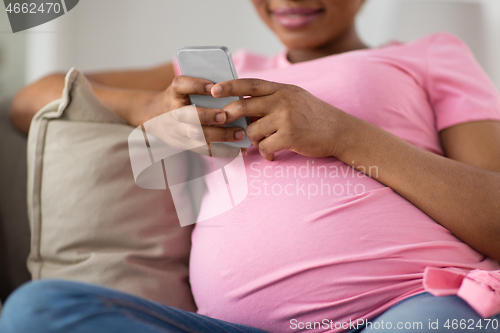 Image of pregnant woman with smartphone at home