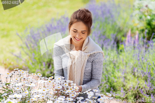 Image of young woman with flowers at summer garden