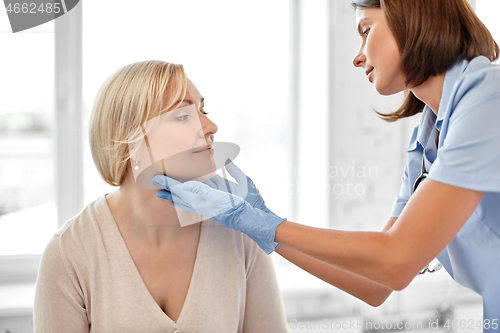 Image of doctor checking patient\'s tonsils at hospital