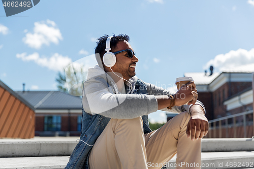 Image of man in headphones listening to music on roof top