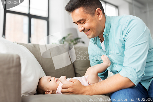 Image of middle aged father playing with baby at home