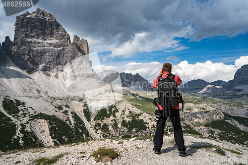 Image of Nature photographer tourist with camera shoots while standing It