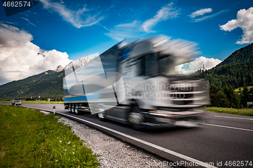 Image of Fuel truck rushes down the highway in the background the Alps. T