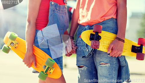 Image of close up of young couple with skateboards in city