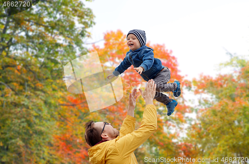 Image of father with son playing and having fun in autumn