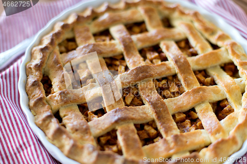 Image of close up of apple pie in baking mold on towel