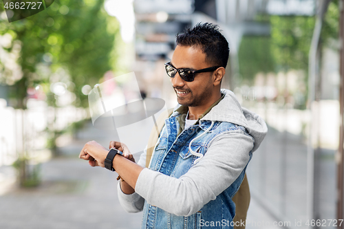 Image of indian man with smart watch and backpack in city