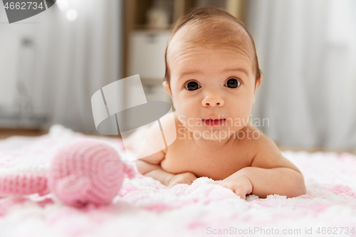 Image of sweet baby girl lying on knitted plush blanket