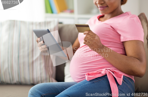 Image of pregnant woman with tablet pc and credit card