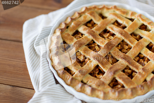 Image of close up of apple pie in mold on wooden table