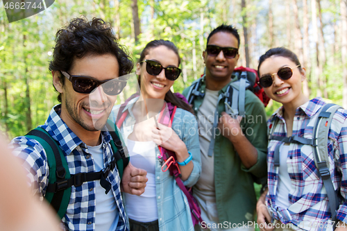 Image of friends with backpacks hiking and taking selfie