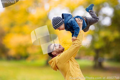 Image of father with son playing and having fun in autumn