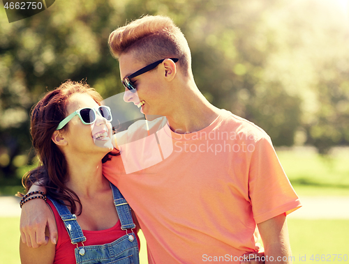 Image of happy teenage couple looking at each other in park