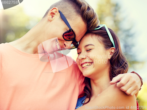 Image of happy teenage couple hugging at summer