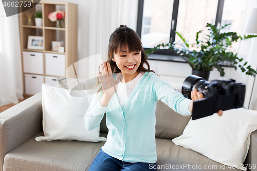 Image of asian female blogger with camera recording video