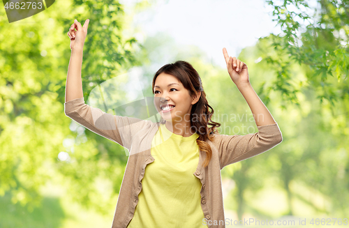 Image of asian woman dancing over green natural background