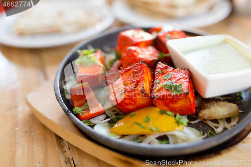 Image of close up of paneer tikka dish with sauce on table