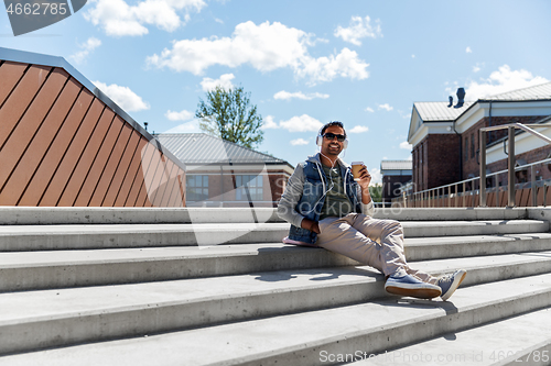 Image of man in headphones listening to music on roof top