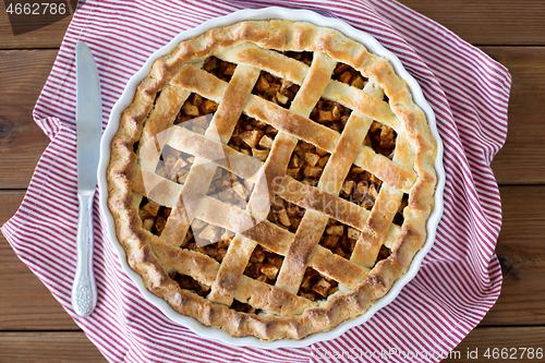 Image of close up of apple pie in baking mold and knife