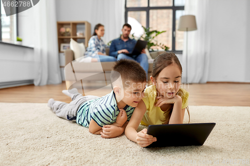 Image of brother and sister with tablet computer at home