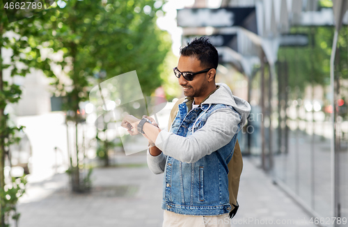 Image of indian man with smart watch and backpack in city