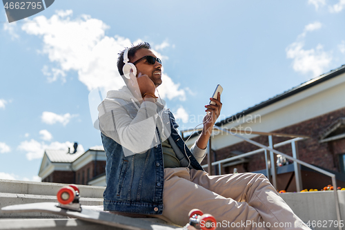 Image of man with smartphone and headphones on roof top